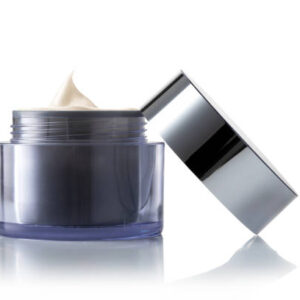 Light brown beauty cosmetic cream in gray glass jar on white background.